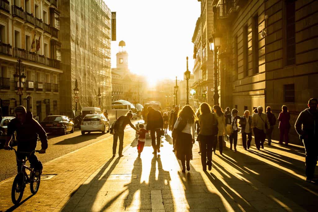 Street in Madrid, golden hour. people walking, bike